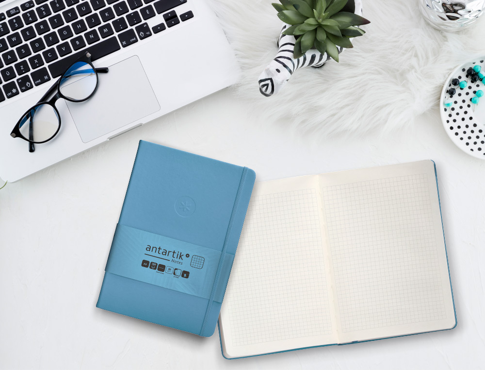 CUADERNO CON GOMILLA ANTARTIK NOTES TAPA DURA A5 HOJAS CUADRICULA AZUL CLARO 100 HOJAS 80 GR FSC